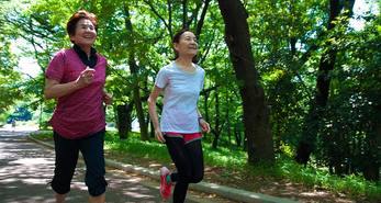 Two senior woman running in a park