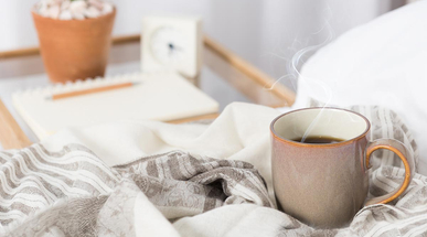 cup-of-coffee-on-cozy-white-bed.jpg