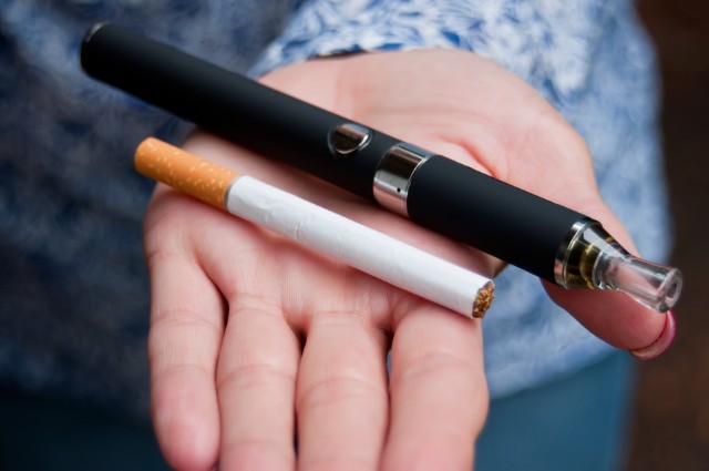 Holding a traditional cigarette and vaping device