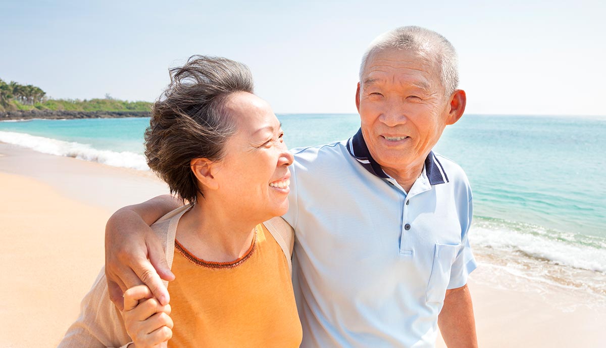 happy-asian-seniors-walking-on-the-beach.jpg