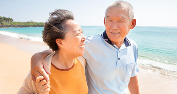 A senior couple walking together on the beach