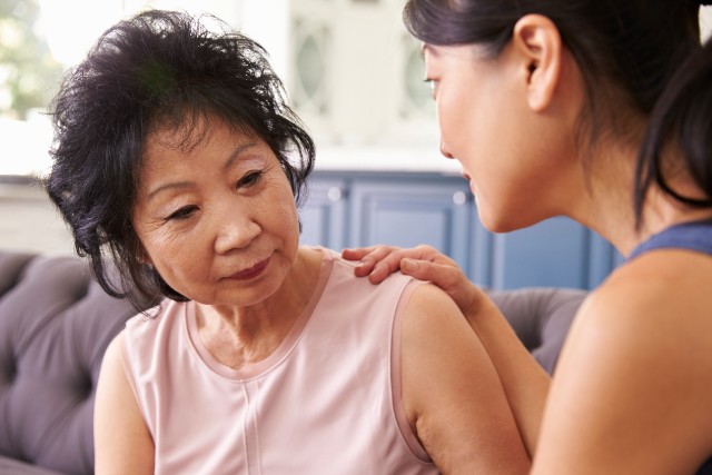 asian woman comforts her grandmother