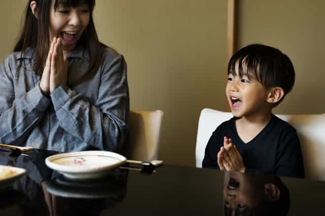 Preschooler preparing to have a meal with the rest of the family.