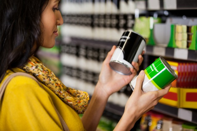 woman shopping at the supermarket comparing labels