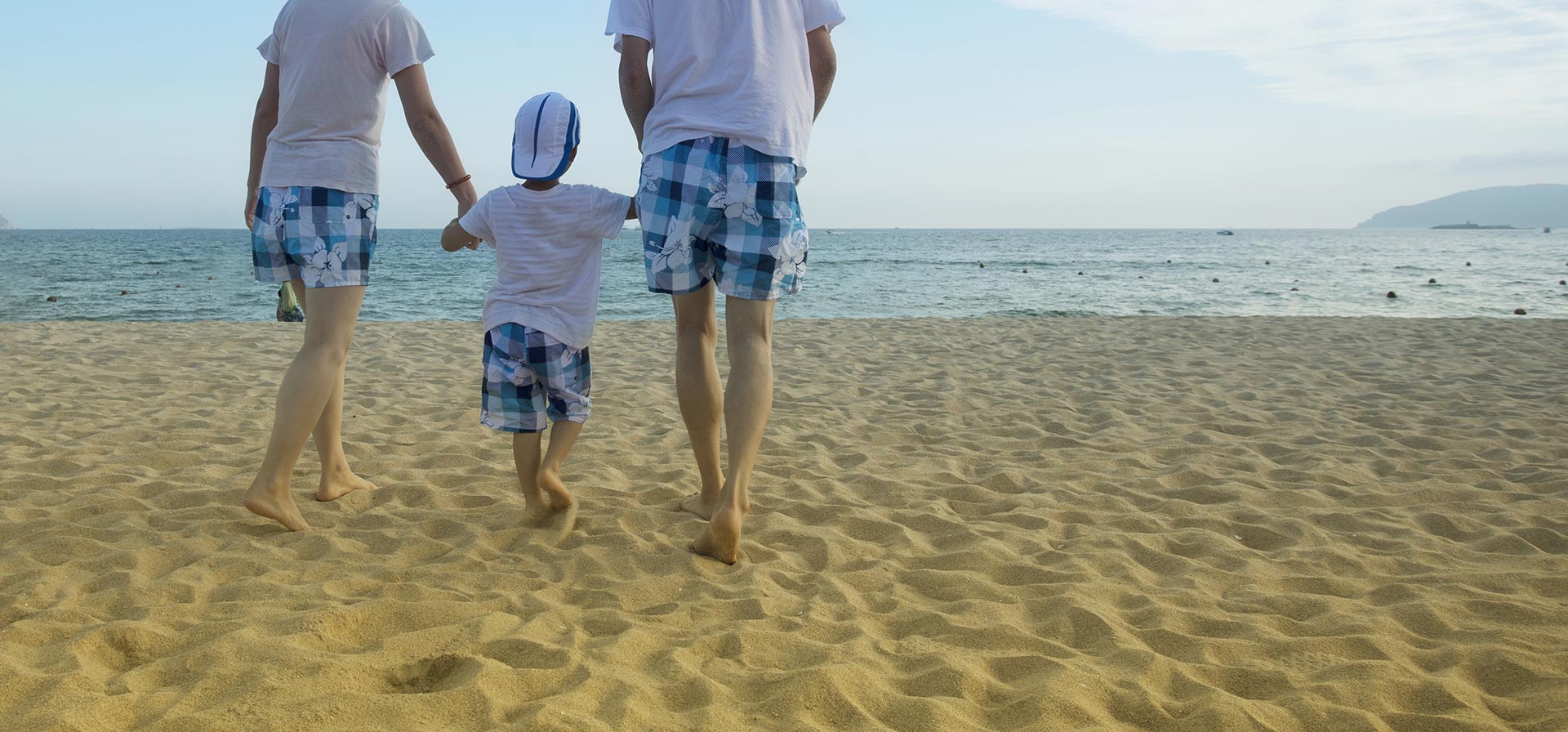 parents-walking-with-child-on-the-beach.jpg