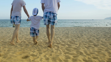 parents-walking-with-child-on-the-beach.jpg
