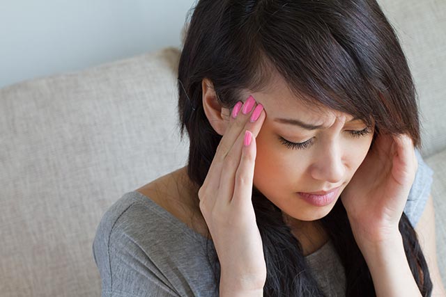 Woman feeling unwell, possibly as a result of using a vape device.