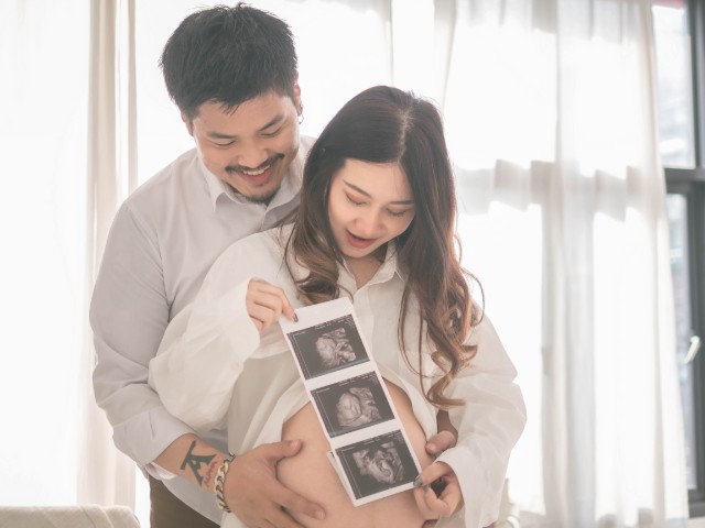 husband hugging his pregnant wife from behind