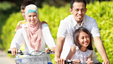 Happy family cycling together after the father joined a smoking cessation programme and learnt to handle the withdrawal.