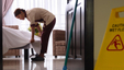 A caregiver cleaning up the house and making the bed