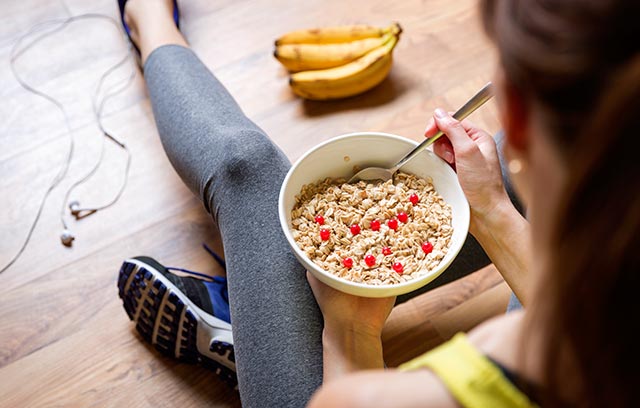 Young girl eating oatmeal with berries after a workout