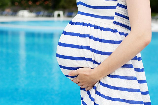 Pregnant mother getting walking to the pool for her exercise