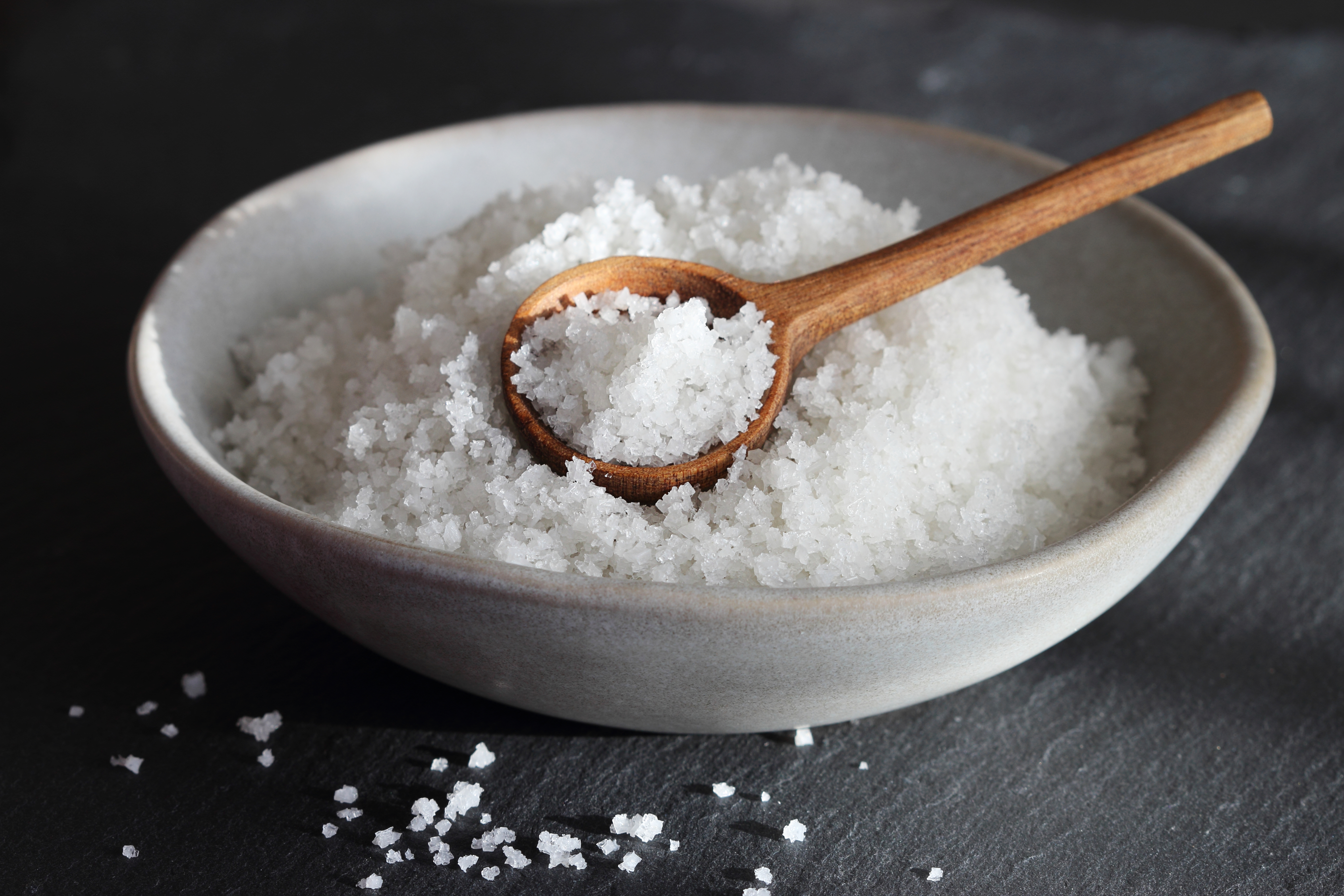Coarse salt in a bowl with a wooden spoon