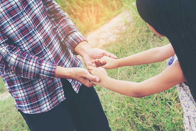 a girl holding hands with father