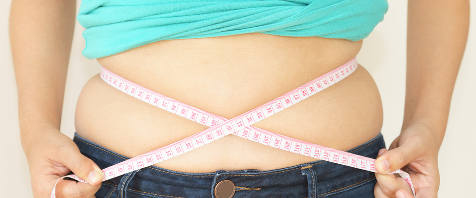 Woman measuring waist with measuring tape,Excess belly fat and