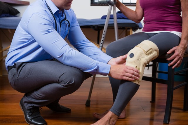 A physical therapist helping a patient with a knee injury.