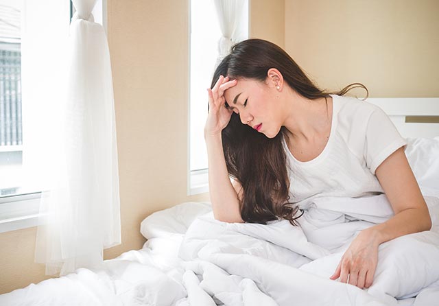 Woman in bed with a bad headache