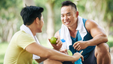 Two friends sitting down and having a break after a workout