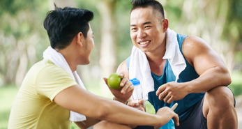 Two friends sitting down and having a break after a workout