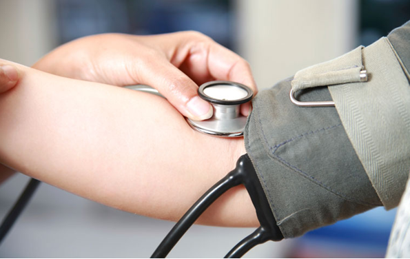 a doctor puts a stethoscope on the patients arm while testing their blood pressure