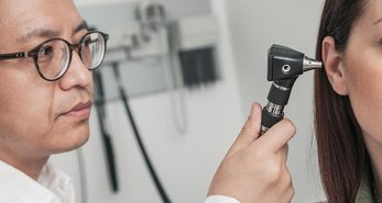 A doctor performing an ear test on a patient