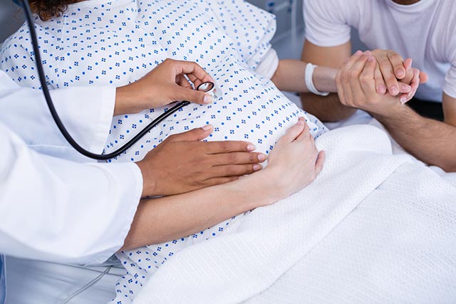 Doctor examining a pregnant woman's belly