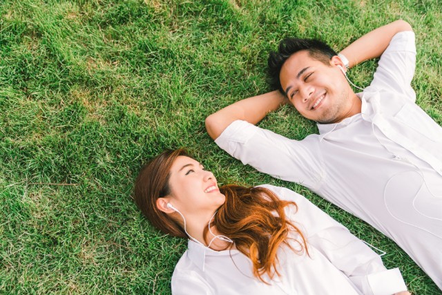 couple lying on the grass and listening to music