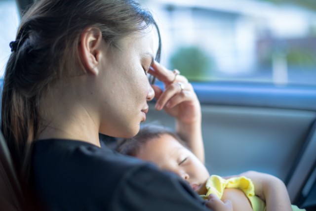 woman with baby looking tired and sad