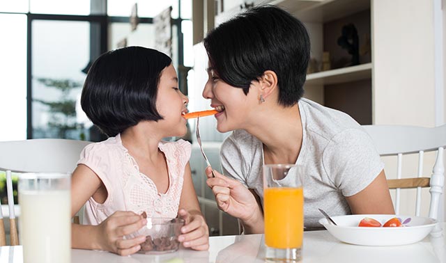 Mother and daughter eating a healthy breakfast together