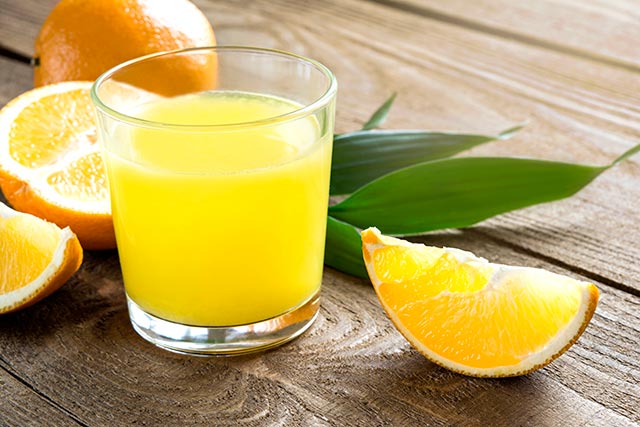 sliced orange and a cup of orange juice