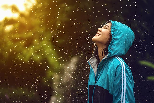 Young woman living in the present moment and enjoying the rain