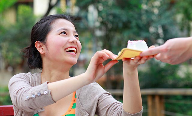 Young woman happily receiving a slice of cake