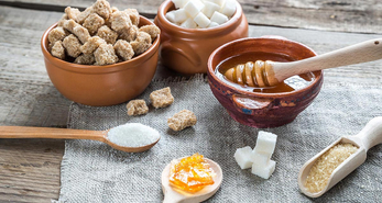 Different types of sugar displayed in various forms on a table cloth