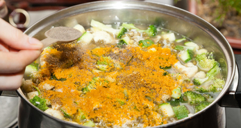 Adding spice into a pot of soup