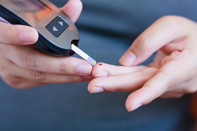 Man testing his blood glucose levels with a glucometer