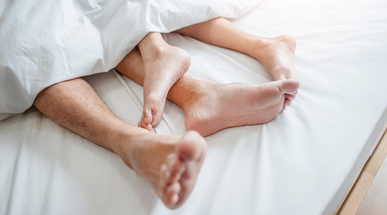 love-lying-in-bed-in-hotel-embracing-on-white-sheets.jpg