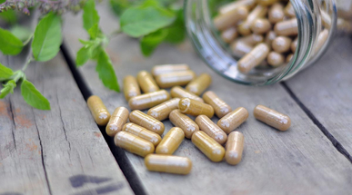 a-full-jar-of-herbal-capsules-tilted-over-and-spilled-oit.jpg
