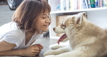 Woman spending time with her dog, which helps to improve her emotional health.