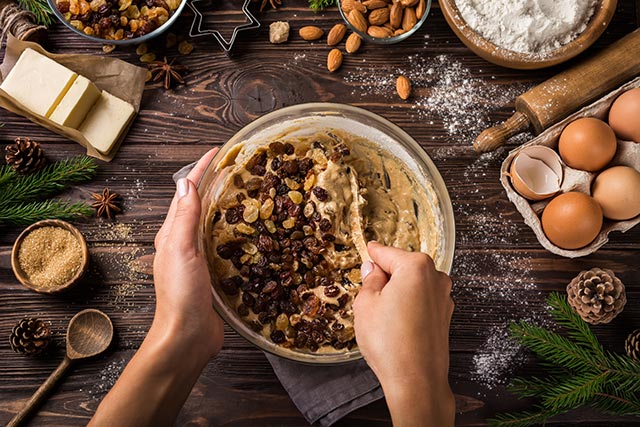 Mixxing in raisins into batter with individual ingredients lying around the table