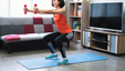 A woman doing squats with small dumbbell indoors.