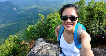 A hiker on a mountain range enjoying the health benefits of hiking.