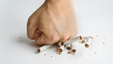 A man crushing cigarettes with his fist