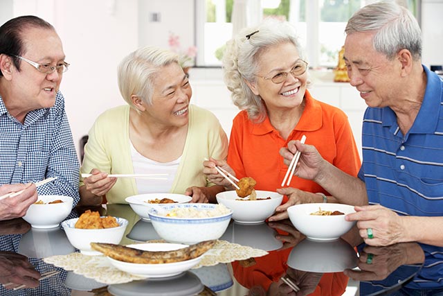 Senior asian friends having lunch together and bonding