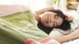 Asian woman waking up with a smile on her face
