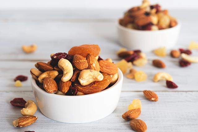 A bowl of mixed nuts contaning almonds, dried cranberries and cashew nuts