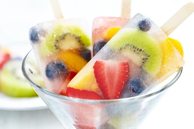 a cup of fresh fruit frozen in a popsicle