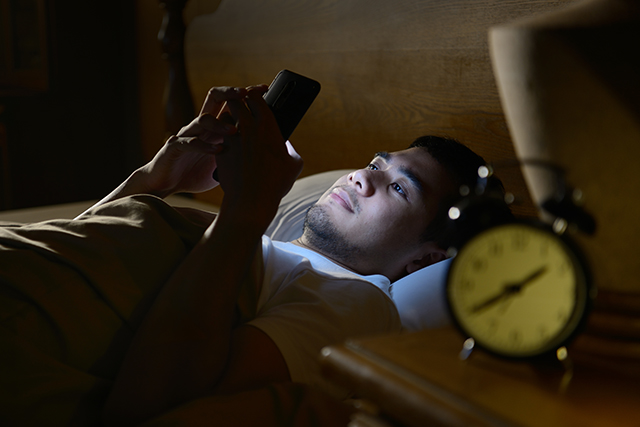 man-using-phone-in-bed