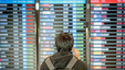 Man checking the departure board in the airport for his flight