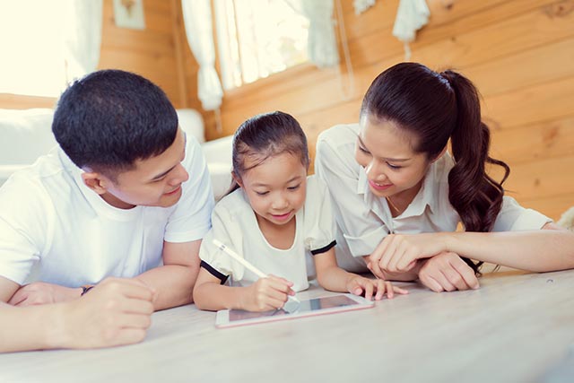 Parents looking at their daughter drawing on the tablet