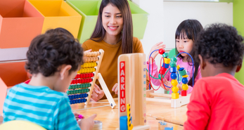 young kids playing in school with teacher